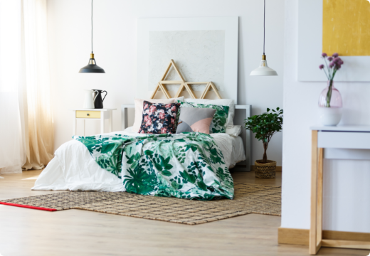 Cama matrimonial en un dormitorio con iluminación natural de la ventana.
