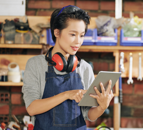 Servicios de Decoración, Mujer con protectores auditivos en el cuello mirando las instrucciones en una Tablet.